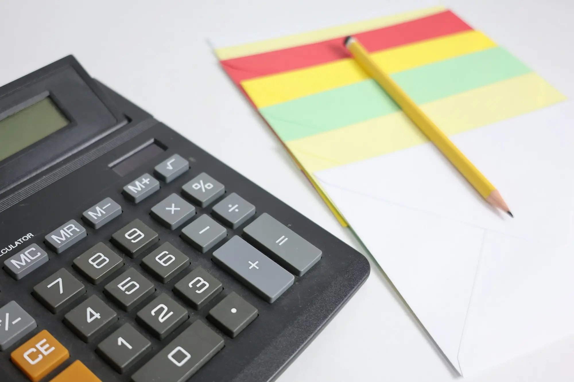 Desk calculator beside a notepad and pencil, ready to compare the tax on buying business premises before or after 1 July 2027