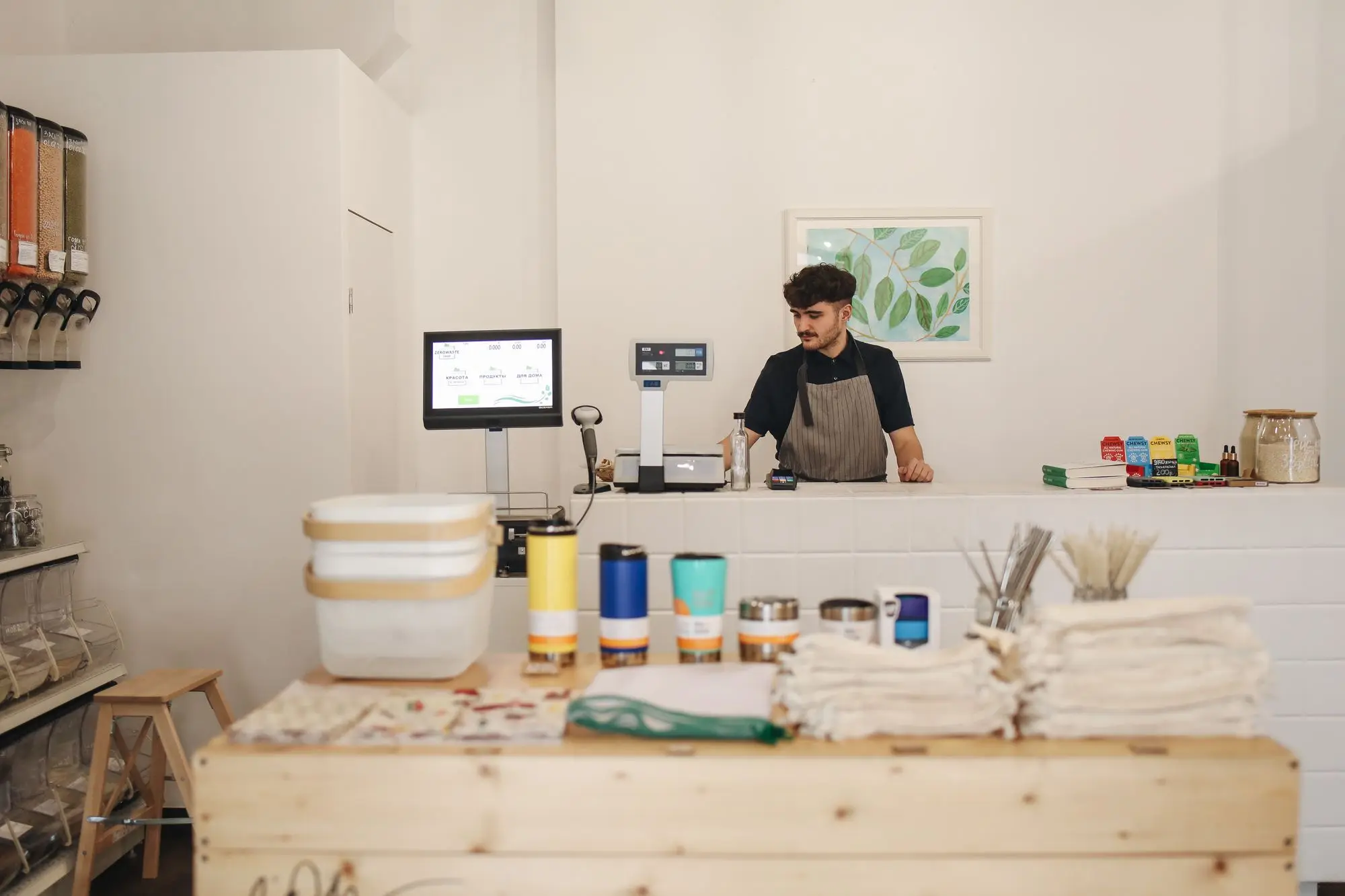 Shop owner standing behind the counter of a small refill and homewares store in a leased shopfront